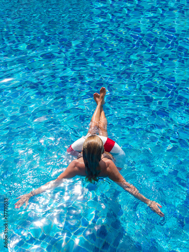 A girl is relaxing in a swimming pool