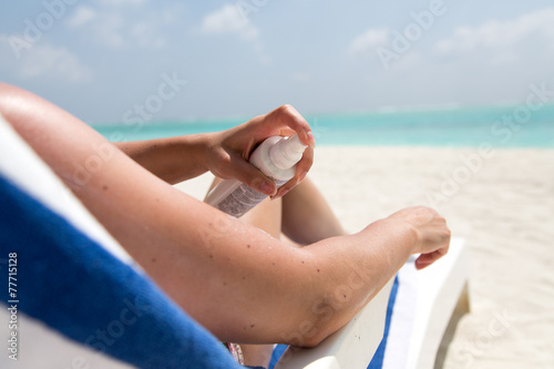 Sonnenschutz am Strand, Frau trägt Lotion auf