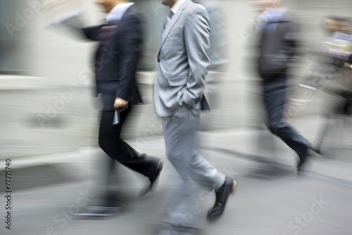 motion blurred business people walking on the street