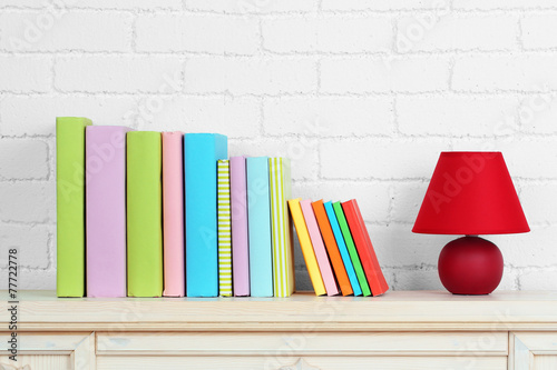 Books on shelf on wall background