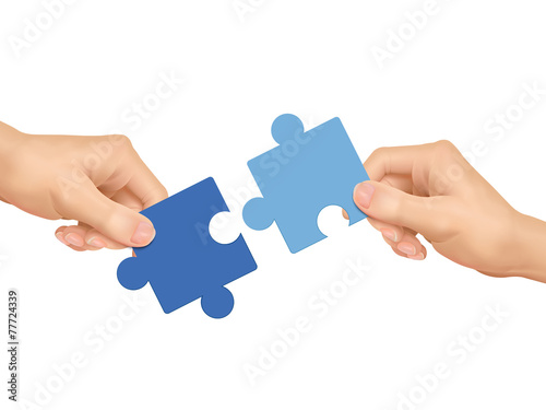 cooperation concept: hands holding jigsaw pieces