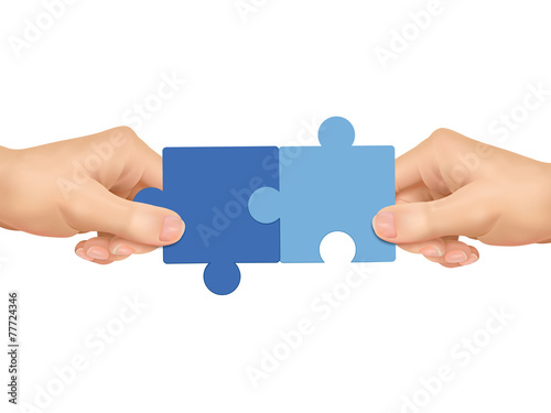 cooperation concept: hands holding jigsaw pieces