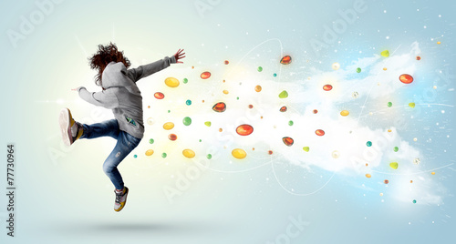 Beautiful woman jumping with colorful gems and crystals on the b