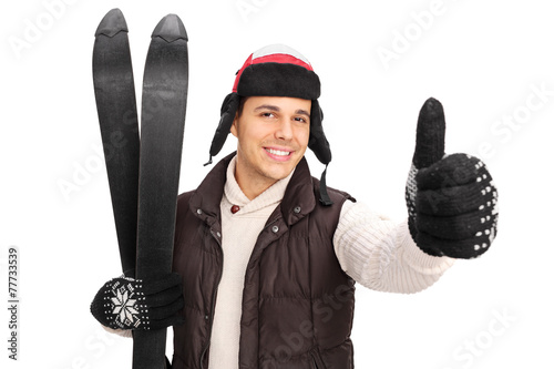 Young man posing with a pair of skis photo