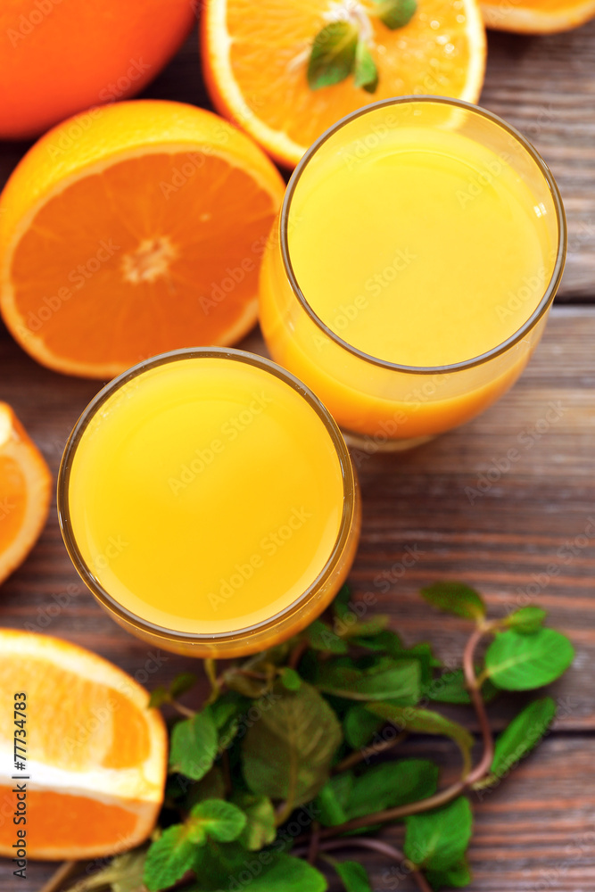 Glass of orange juice and slices on wooden table background Glass of orange juice and slices on wooden table background