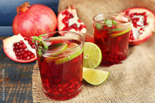 Pomegranate drink in glasses with slices of lime and mint