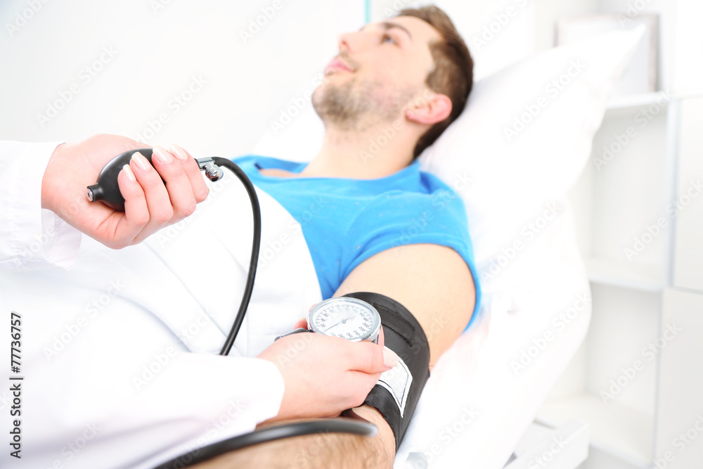 Fototapeta premium Doctor measuring patient pressure close up