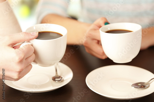 Two women with cups of coffee close up