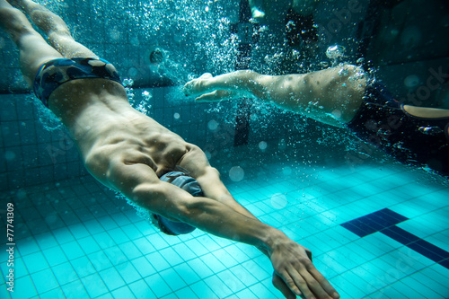 Swimmers at the swimming pool.Underwater photo.