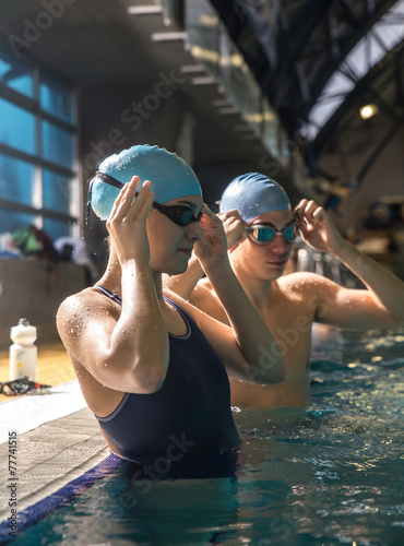 Two swimmers preparing to race at the swimming pool.
