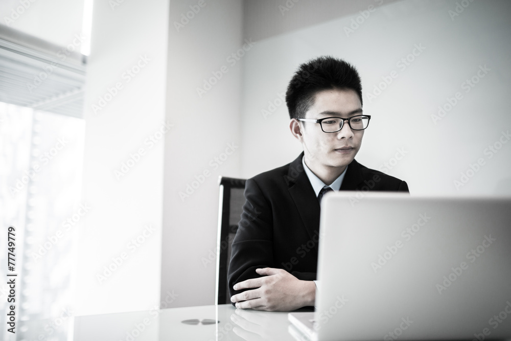 Young handsome man using laptop in his office Young handsome man using laptop in his office