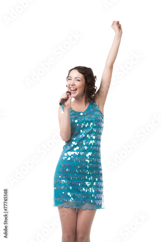 Happy young woman singing in short sparkling blue dress