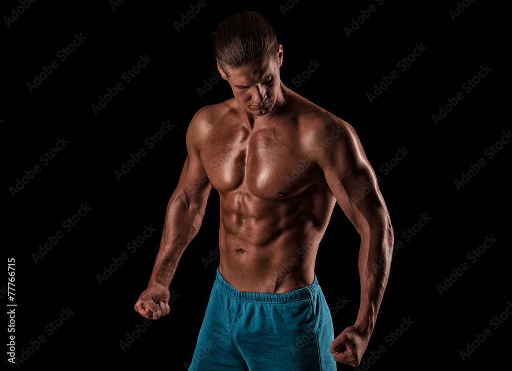 Handsome muscular bodybuilder posing over black background. Handsome muscular bodybuilder posing over black background.