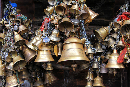 Metal sacrificial bells hanging on chain at Kumbeshwar Temple photo