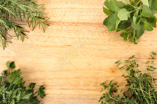 Fresh herbs on the corner of chopping board. Space for copy.