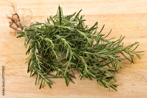 Bunch of fresh rosemary on an old wooden chopping board