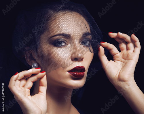 beauty brunette woman under black veil with red manicure close