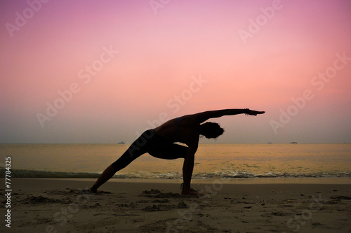 silhouette of woman practicing yoga on the beach sunrise