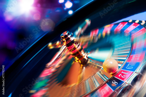 Roulette wheel in motion with a bright and colorful background photo