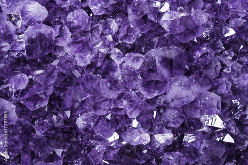 Dettaglio ravvicinato dei cristalli viola chiaro di un ametista gigante con qualche riflesso e luce piatta. 