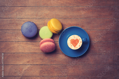 Cup and macarons on wooden background