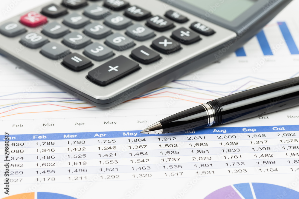 Sales report analysis with pen, and calculator Sales report analysis with pen, and calculator