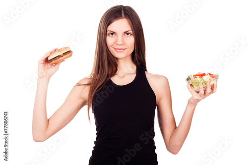 A woman holding a burger and a salad