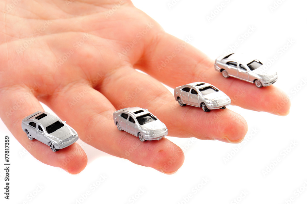 人間の手のひらを走っているたくさんの車