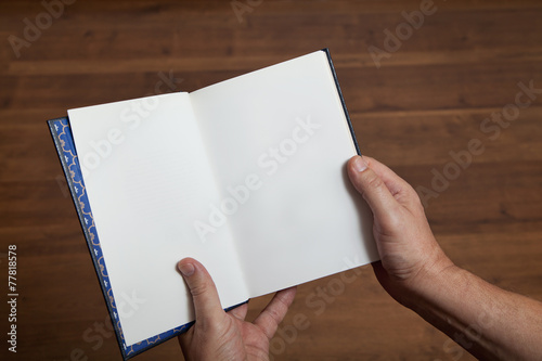 Male hands holding an open book