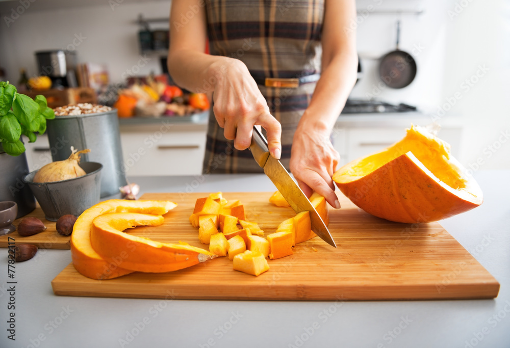 Closeup on young housewife cutting pumpkin Closeup on young housewife cutting pumpkin