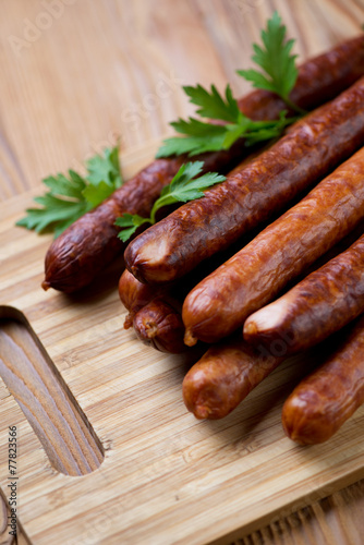 Close-up of smoked sausages on a wooden chopping board
