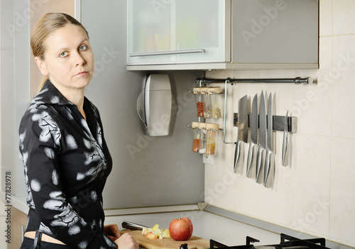 Obraz na płótnie Woman cut an apple in the kitchen w salonie