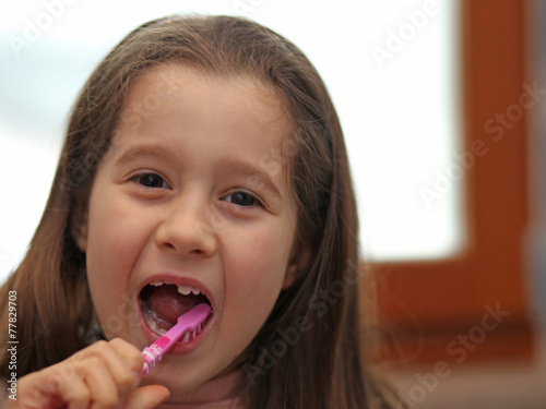 little girl without a tooth while brushing teeth