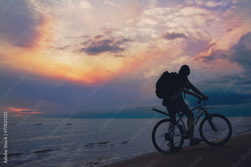 Mountain biker on beach and sunset Mountain biker on beach and sunset