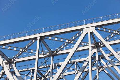 Construction truss bridge on background of blue sky