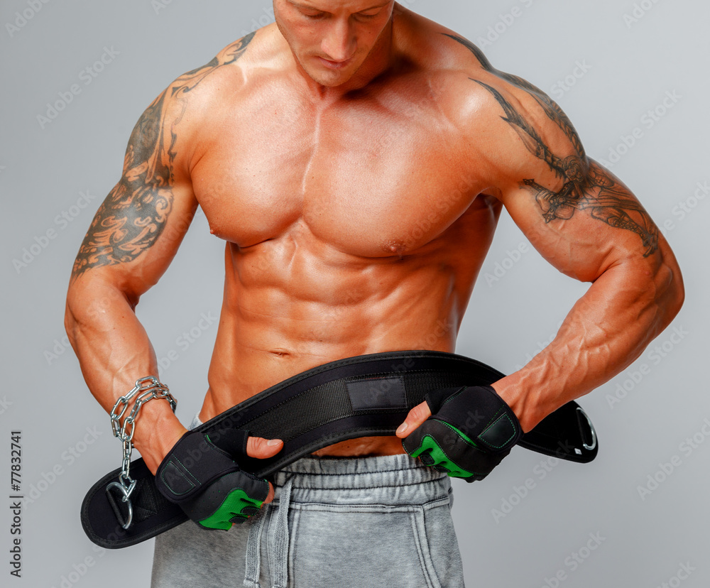 Naklejka premium Strong muscular man poses showing his body.
