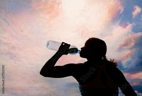 Beautiful young blond girl drinking water