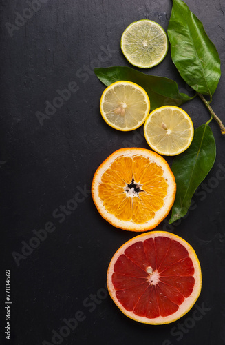 Set of sliced citrus fruits over black texture.Top view