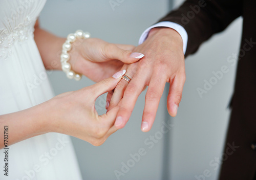 bride wears a gold ring to the groom wedding photo