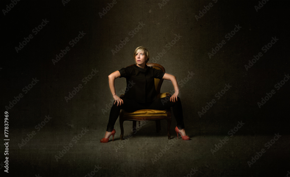 woman in black sitting on a yellow sofa woman in black sitting on a yellow sofa