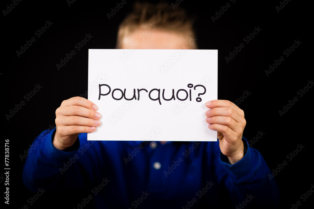 Child holding sign with French word Pourquoi - Why Child holding sign with French word Pourquoi - Why