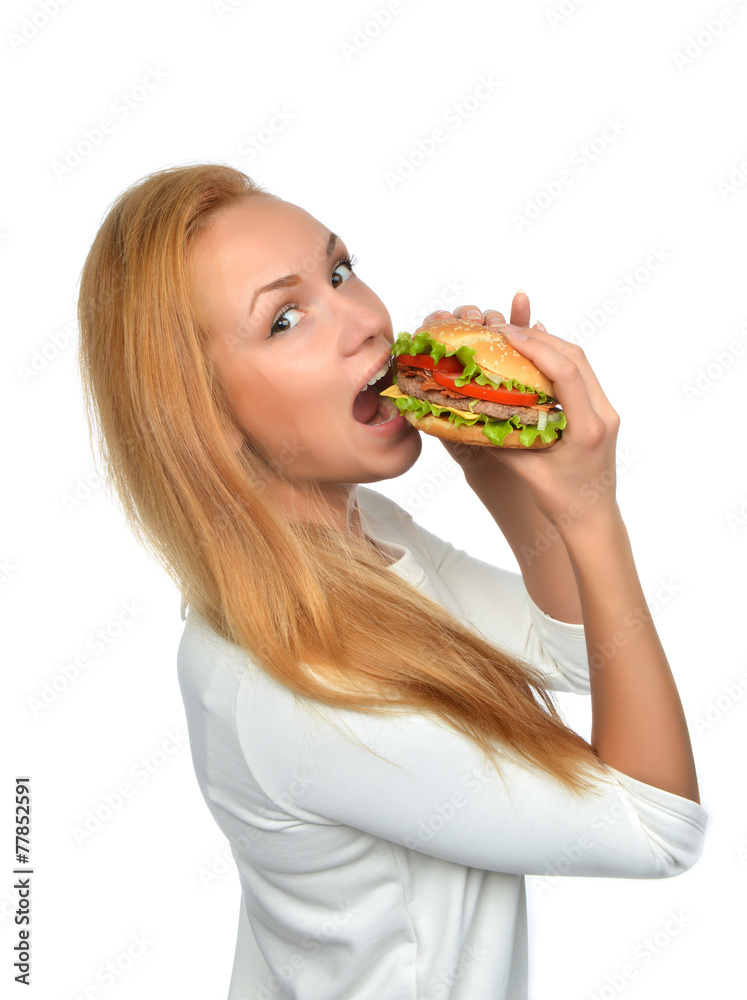 Fast food concept. Woman eating tasty unhealthy burger sandwich