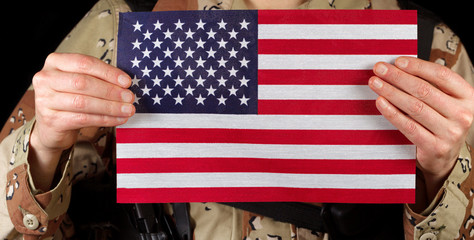 American flag being held by male soldier