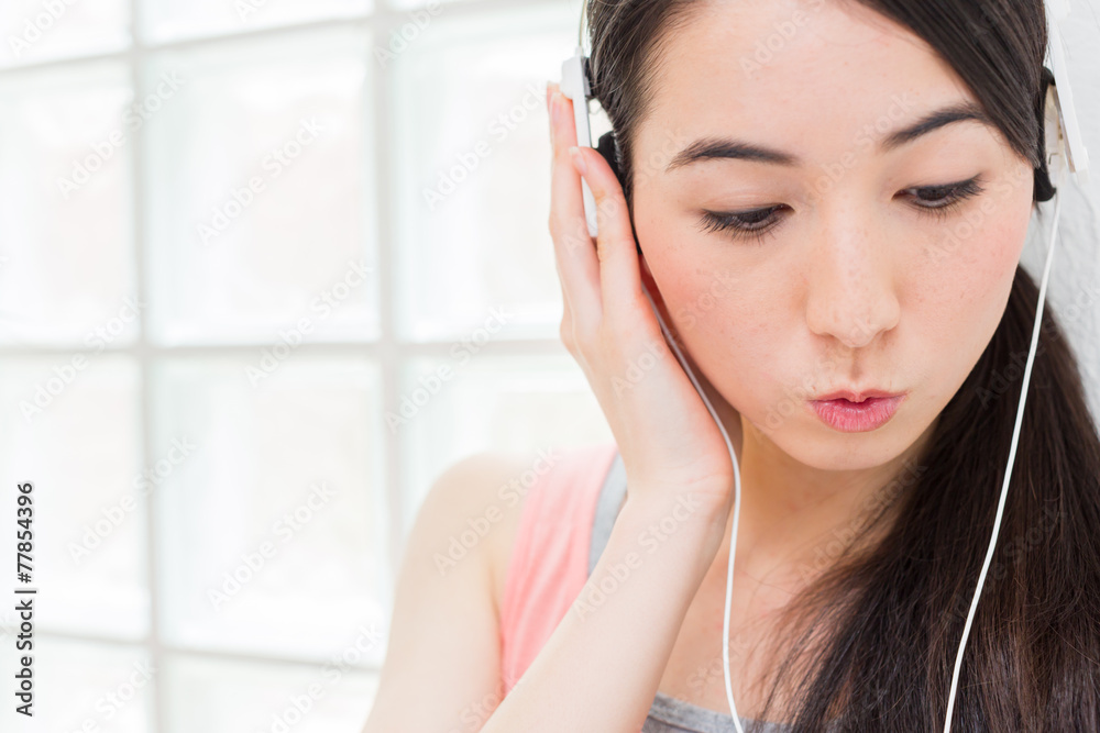 ヘッドフォンで音楽を聴く女性 ヘッドフォンで音楽を聴く女性
