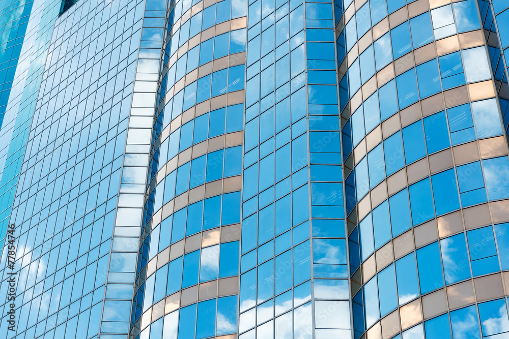 Clouds reflected in windows of modern office building Clouds reflected in windows of modern office building