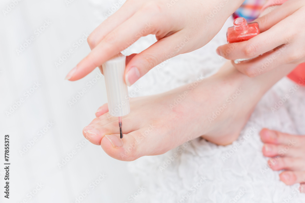 足にマネキュアを塗る女性