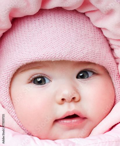 Beautiful baby in a pink hat. Winter season