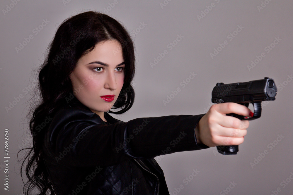 beautiful sexy woman in black with gun over grey beautiful sexy woman in black with gun over grey