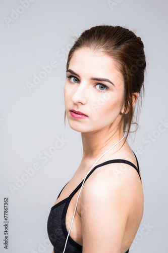 Portrait of attractive woman standing over gray background
