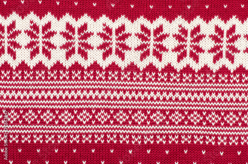 Knit woolen texture.Winter snowflakes shapes pattern background.